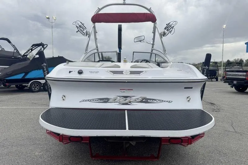 Slide: The Image of 2006 Tigé 22Ve boat with wakeboard tower and swim platform, parked outdoors. - 8