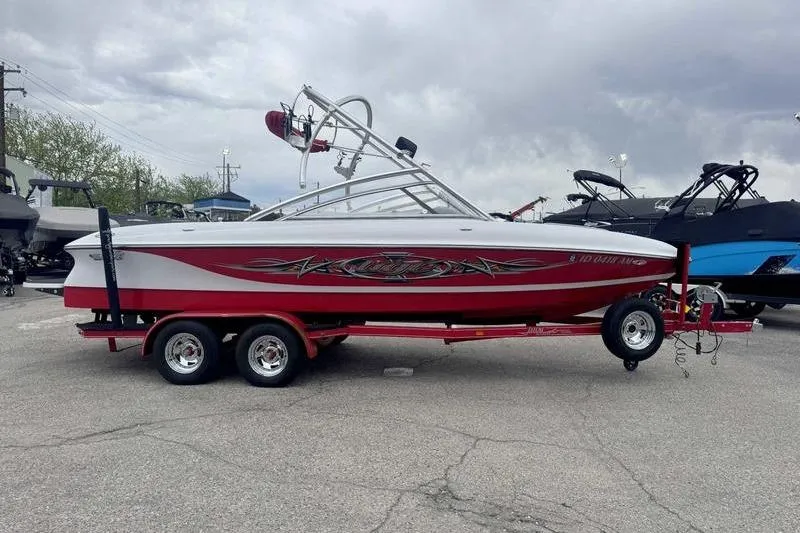 Slide: The Image of 2006 Tigé 22Ve boat on trailer, red and white design, parked outdoors. - 9