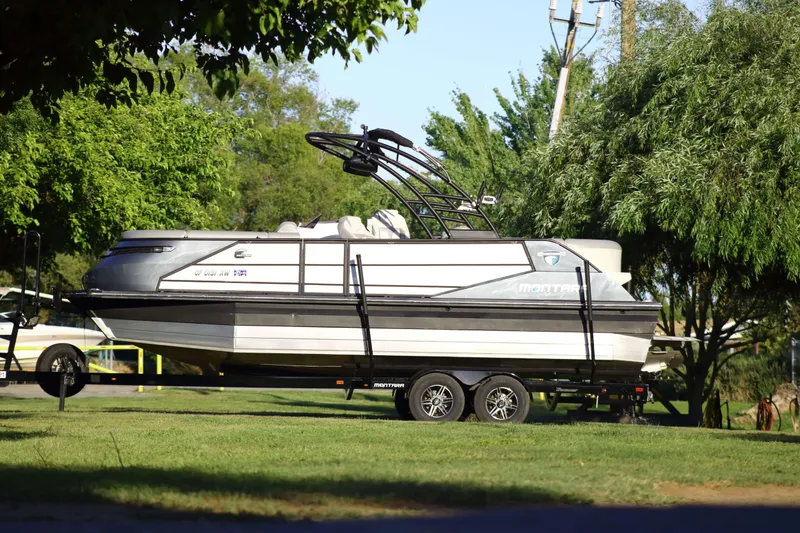 The Image of 2021 Montara Surf Boss 2.0 25 boat on trailer, parked on grassy area. - 1