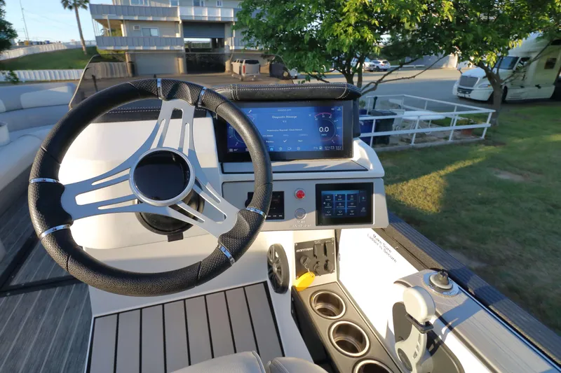 Slide: The Image of 2021 Montara Surf Boss 2.0 25 boat dashboard with steering wheel and digital display. - 13