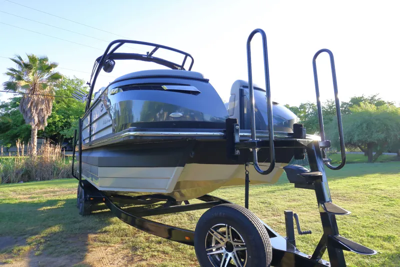 Slide: The Image of 2021 Montara Surf Boss 2.0 25 boat on trailer, parked on grassy area. - 3