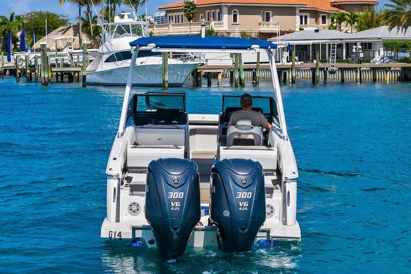 Slide: The Image of 2022 Cobalt R8 Outboard boat cruising on clear blue water near a dock. - 11