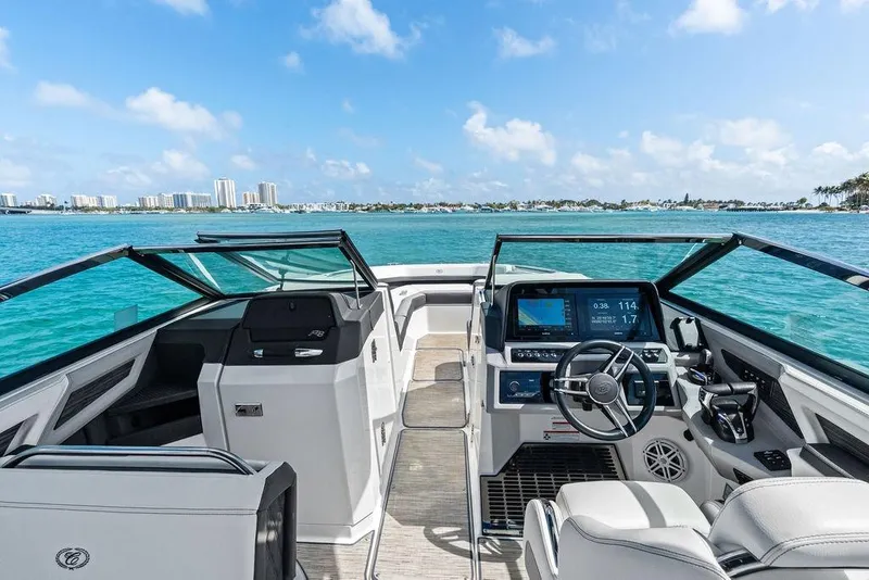 Slide: The Image of 2022 Cobalt R8 Outboard boat interior with modern dashboard, cruising on clear blue waters. - 25