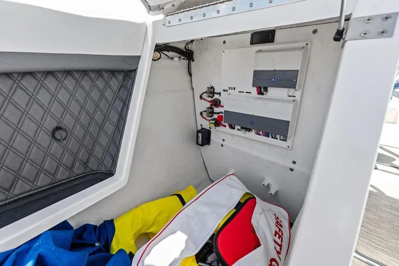 Slide: The Image of 2022 Cobalt R8 Outboard storage compartment with safety gear and electrical panel. - 36