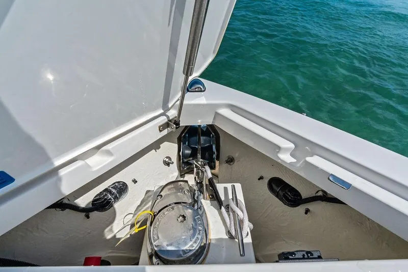 Slide: The Image of 2022 Cobalt R8 Outboard boat anchor compartment with open hatch, near water. - 38