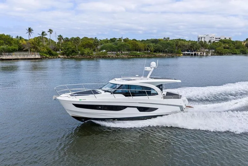 The Image of 2022 Beneteau Antares 11 cruising on a scenic river with lush greenery. - 0