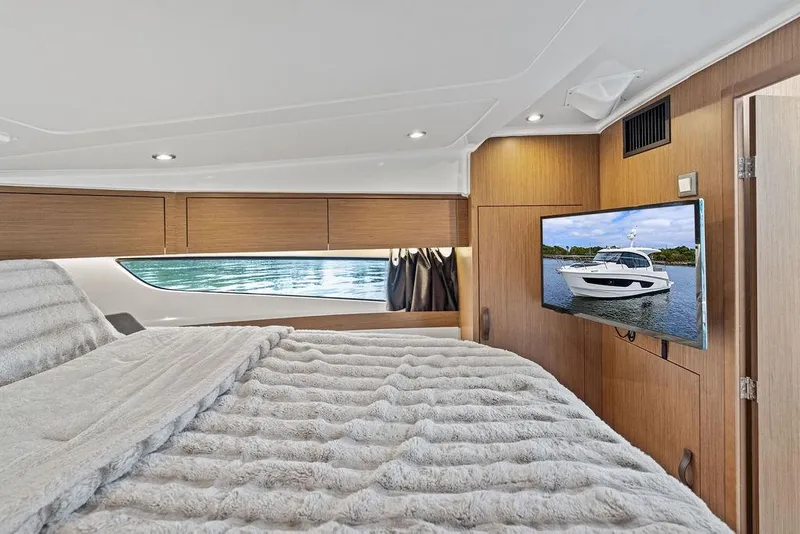 Slide: The Image of Luxurious cabin interior of 2022 Beneteau Antares 11 with cozy bedding and wall-mounted TV. - 12
