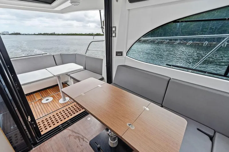 Slide: The Image of Interior view of 2022 Beneteau Antares 11 yacht with seating and table, overlooking water. - 16