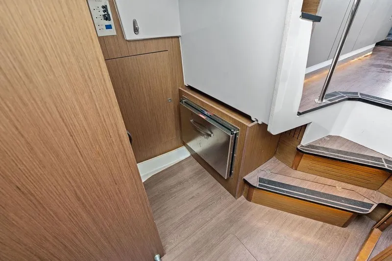 Slide: The Image of Interior view of 2022 Beneteau Antares 11, featuring wooden flooring and compact stairs. - 21