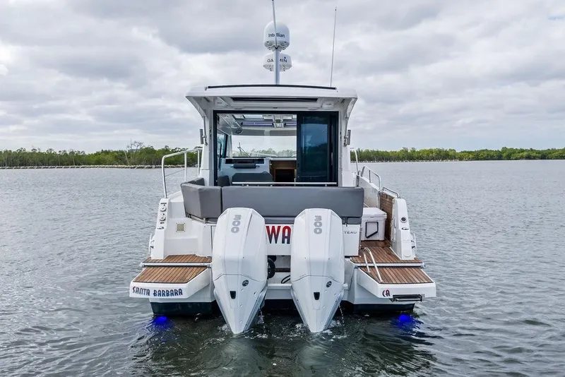 Slide: The Image of 2022 Beneteau Antares 11 boat on water, rear view with twin engines. - 24