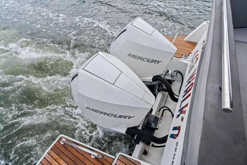 Slide: The Image of Twin Mercury outboard engines on a 2022 Beneteau Antares 11, cruising through water. - 25