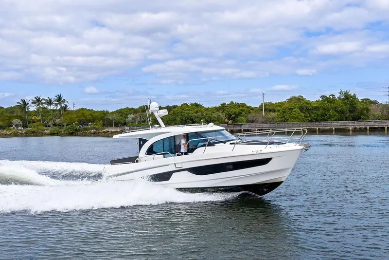 Slide: The Image of 2022 Beneteau Antares 11 cruising on a scenic waterway with lush greenery. - 3