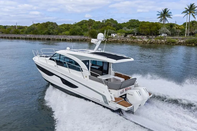 Slide: The Image of 2022 Beneteau Antares 11 cruising on a scenic waterway with lush greenery. - 7