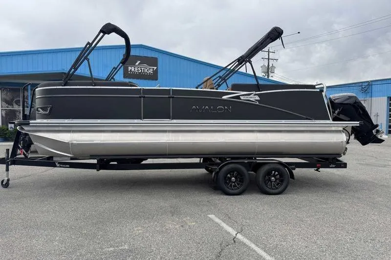 The Image of 2026 Avalon 2385 25 Catalina QL pontoon boat on trailer, parked outside blue building. - 1