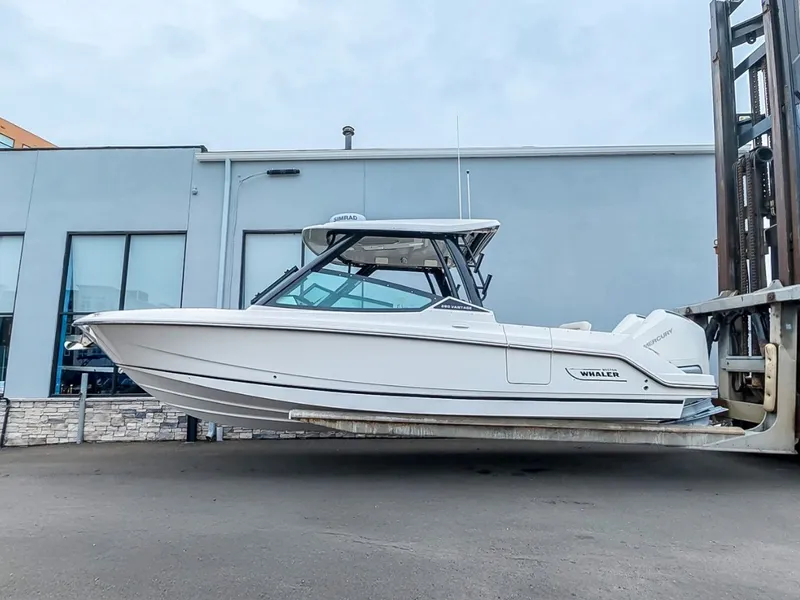 Slide: The Image of A 2027 Boston Whaler 280 Vantage is held by a forklift in front of a building. - 1