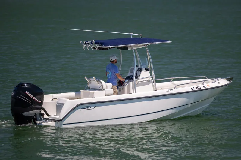 The Image of 2006 Boston Whaler 210 Outrage boat cruising on water with Mercury engine. - 1