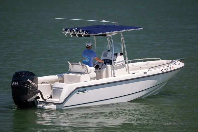 Slide: The Image of 2006 Boston Whaler 210 Outrage boat cruising on calm water with a Mercury engine. - 10