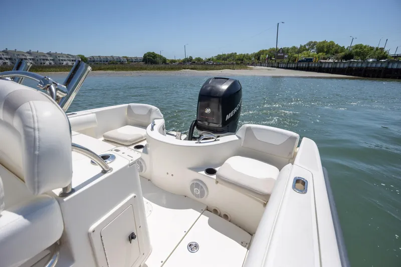 Slide: The Image of 2006 Boston Whaler 210 Outrage boat on water, featuring Mercury engine and white seating. - 11