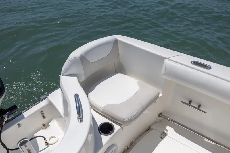 Slide: The Image of 2006 Boston Whaler 210 Outrage boat interior with white seating and ocean backdrop. - 14