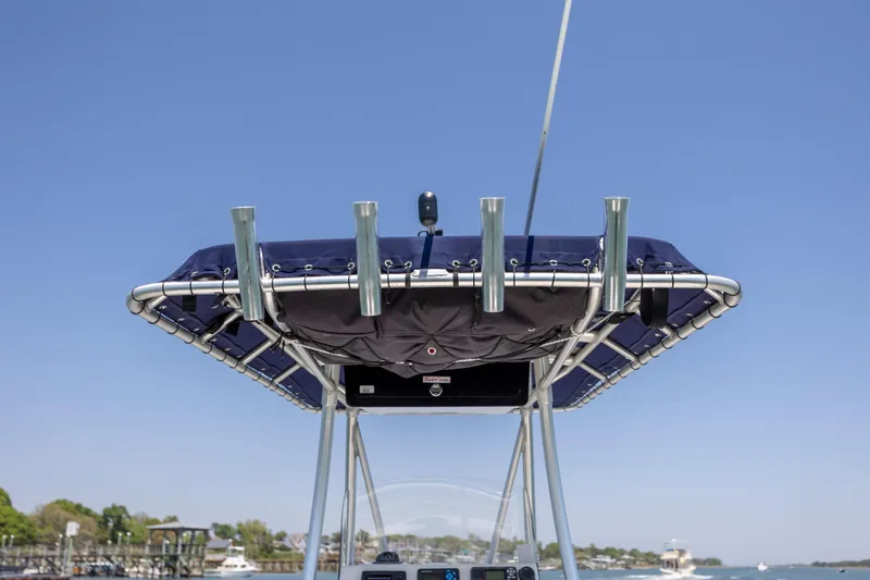 Slide: The Image of Boston Whaler 210 Outrage 2006 boat with T-top and rod holders against clear sky. - 17