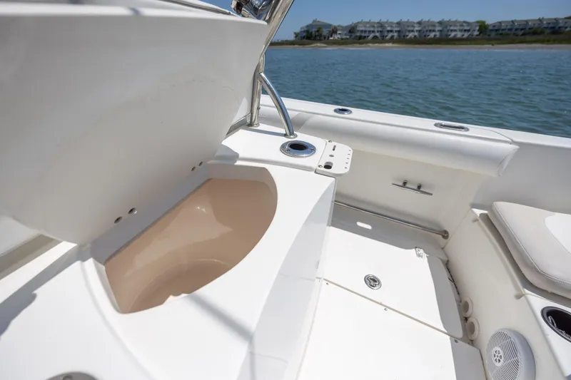 Slide: The Image of 2006 Boston Whaler 210 Outrage boat interior with seating and storage, near waterfront homes. - 20