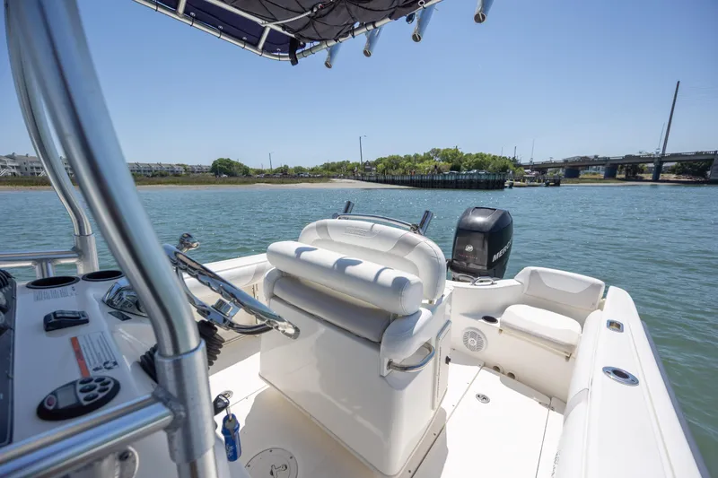 Slide: The Image of 2006 Boston Whaler 210 Outrage boat on water, featuring helm and seating area. - 21