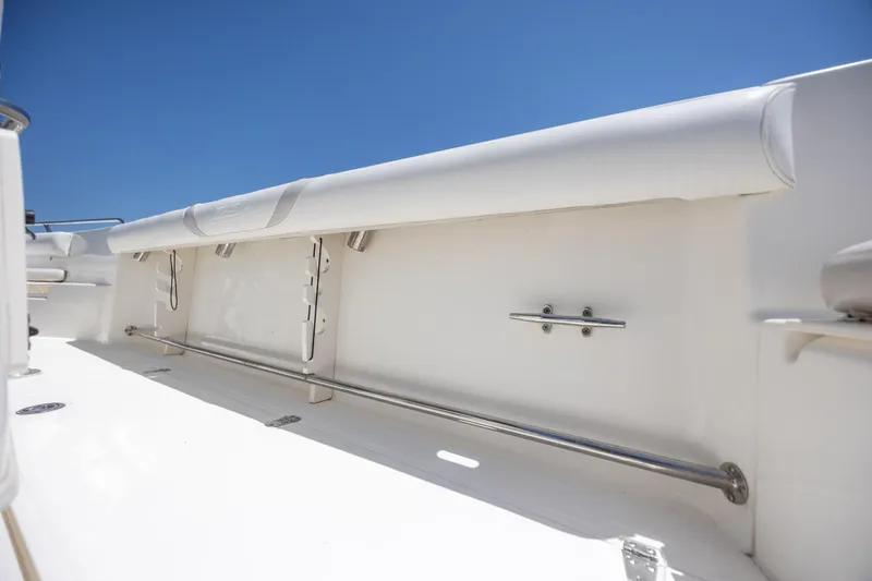 Slide: The Image of 2006 Boston Whaler 210 Outrage interior detail with stainless steel railing and white upholstery. - 22