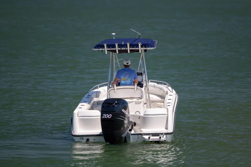 Slide: The Image of 2006 Boston Whaler 210 Outrage boat on water, rear view with outboard motor. - 3