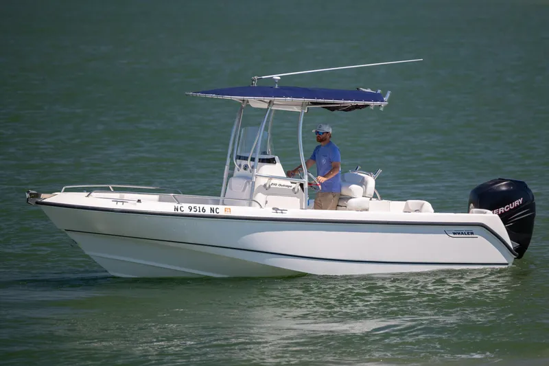 Slide: The Image of 2006 Boston Whaler 210 Outrage boat cruising on calm water with a Mercury engine. - 6