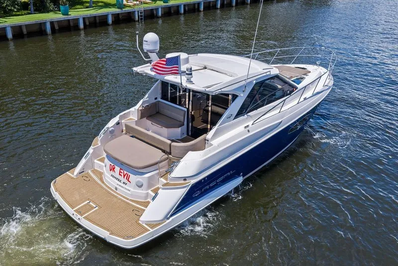 Slide: The Image of 2013 Regal 42 Sport Coupe yacht cruising on a serene waterway. - 10