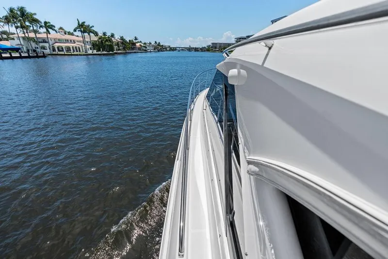 Slide: The Image of 2013 Regal 42 Sport Coupe cruising on a scenic waterway with palm trees. - 11
