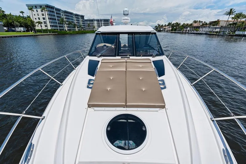 Slide: The Image of 2013 Regal 42 Sport Coupe yacht on a scenic waterway with modern buildings. - 12
