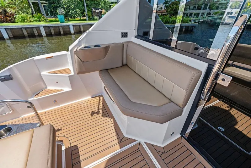 Slide: The Image of Luxurious seating area on 2013 Regal 42 Sport Coupe yacht, featuring elegant design and wood flooring. - 16