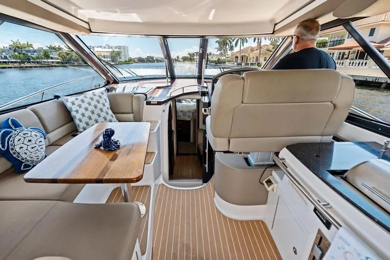 Slide: The Image of Interior of a 2013 Regal 42 Sport Coupe yacht with plush seating and elegant wood finishes. - 21