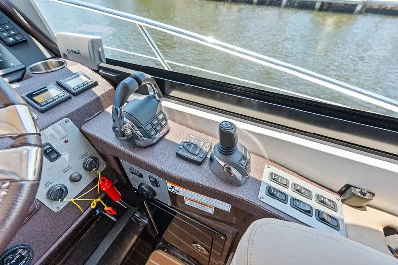 Slide: The Image of Helm controls of a 2013 Regal 42 Sport Coupe yacht, featuring navigation and throttle systems. - 27