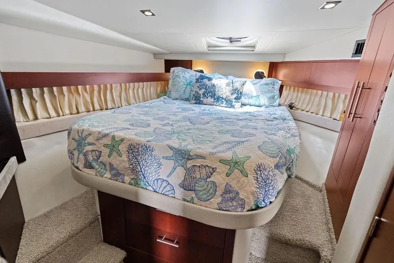 Slide: The Image of Luxurious 2013 Regal 42 Sport Coupe bedroom with nautical-themed bedding and elegant wood accents. - 35