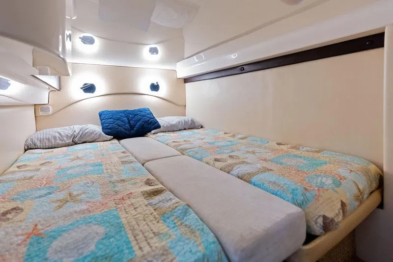 Slide: The Image of Cozy cabin interior of 2013 Regal 42 Sport Coupe with patterned bedding and ambient lighting. - 41