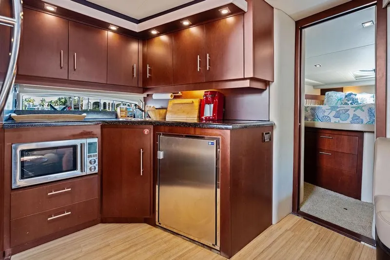 Slide: The Image of Luxurious 2013 Regal 42 Sport Coupe yacht kitchen with modern appliances and elegant wood cabinetry. - 45