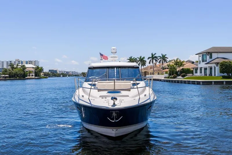 Slide: The Image of 2013 Regal 42 Sport Coupe yacht cruising on a scenic waterway with luxury homes. - 5