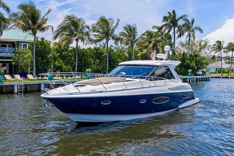 Slide: The Image of 2013 Regal 42 Sport Coupe yacht cruising on a sunny day with palm trees in the background. - 6