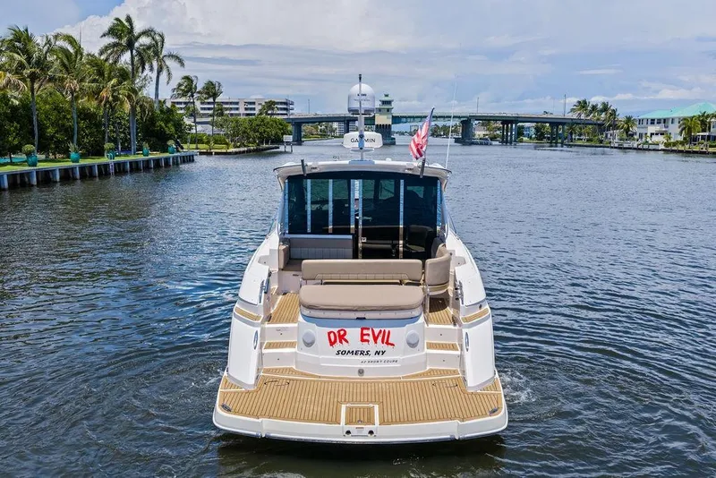 Slide: The Image of 2013 Regal 42 Sport Coupe yacht cruising on a scenic waterway with palm trees. - 8