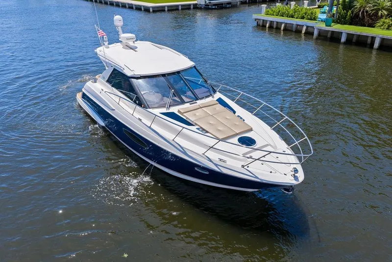 Slide: The Image of 2013 Regal 42 Sport Coupe cruising on a calm waterway, showcasing sleek design and luxury features. - 9