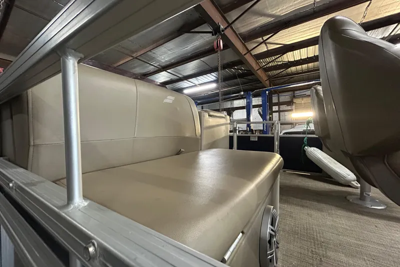 Slide: The Image of 2023 Starcraft LX 18 F boat interior with beige seating in a warehouse. - 13