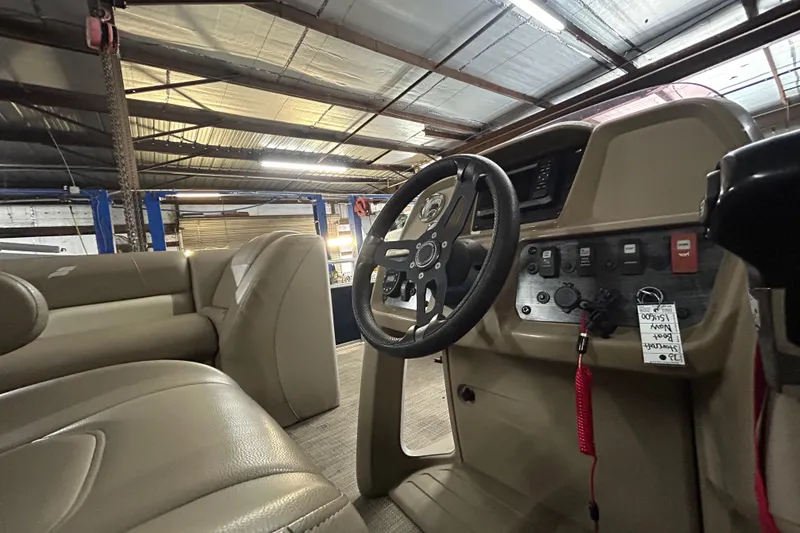 Slide: The Image of Interior view of 2023 Starcraft LX 18 F boat, featuring steering wheel and control panel. - 14