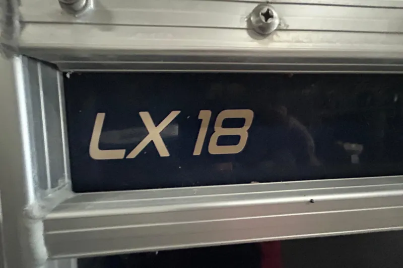 Slide: The Image of 2023 Starcraft LX 18 F boat model emblem on metallic surface. - 16