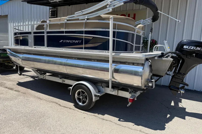 Slide: The Image of 2023 Starcraft LX 18 F pontoon boat on trailer with Suzuki outboard motor. - 19