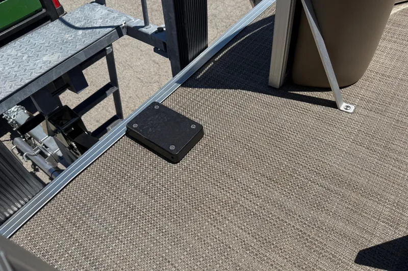 Slide: The Image of 2023 Starcraft LX 18 F boat deck with textured flooring and metal railing. - 25