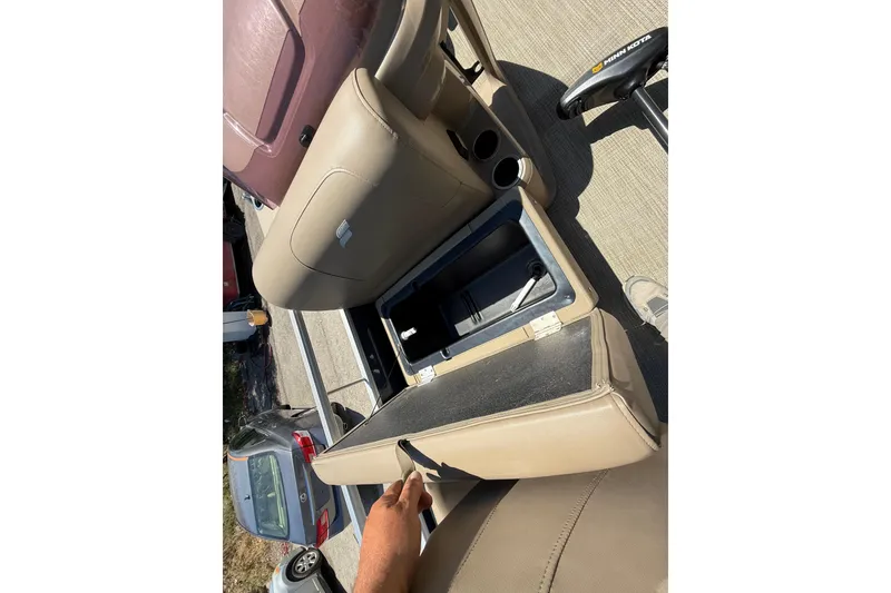 Slide: The Image of 2023 Starcraft LX 18 F boat interior with open storage compartment and beige seating. - 30