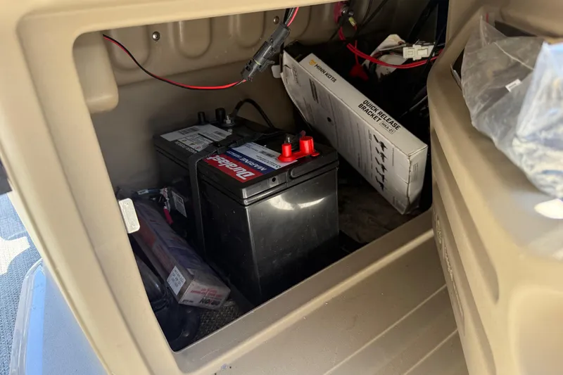 Slide: The Image of Battery compartment of 2023 Starcraft LX 18 F boat, featuring a marine battery and wiring. - 41
