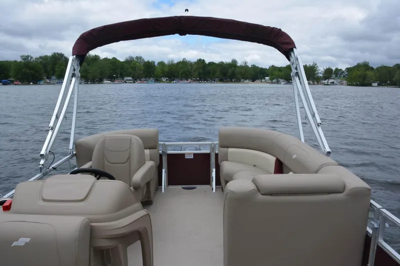Slide: The Image of Manufacturer Provided Image: 2023 Starcraft LX 18 F pontoon boat on a lake with beige seating. - 47